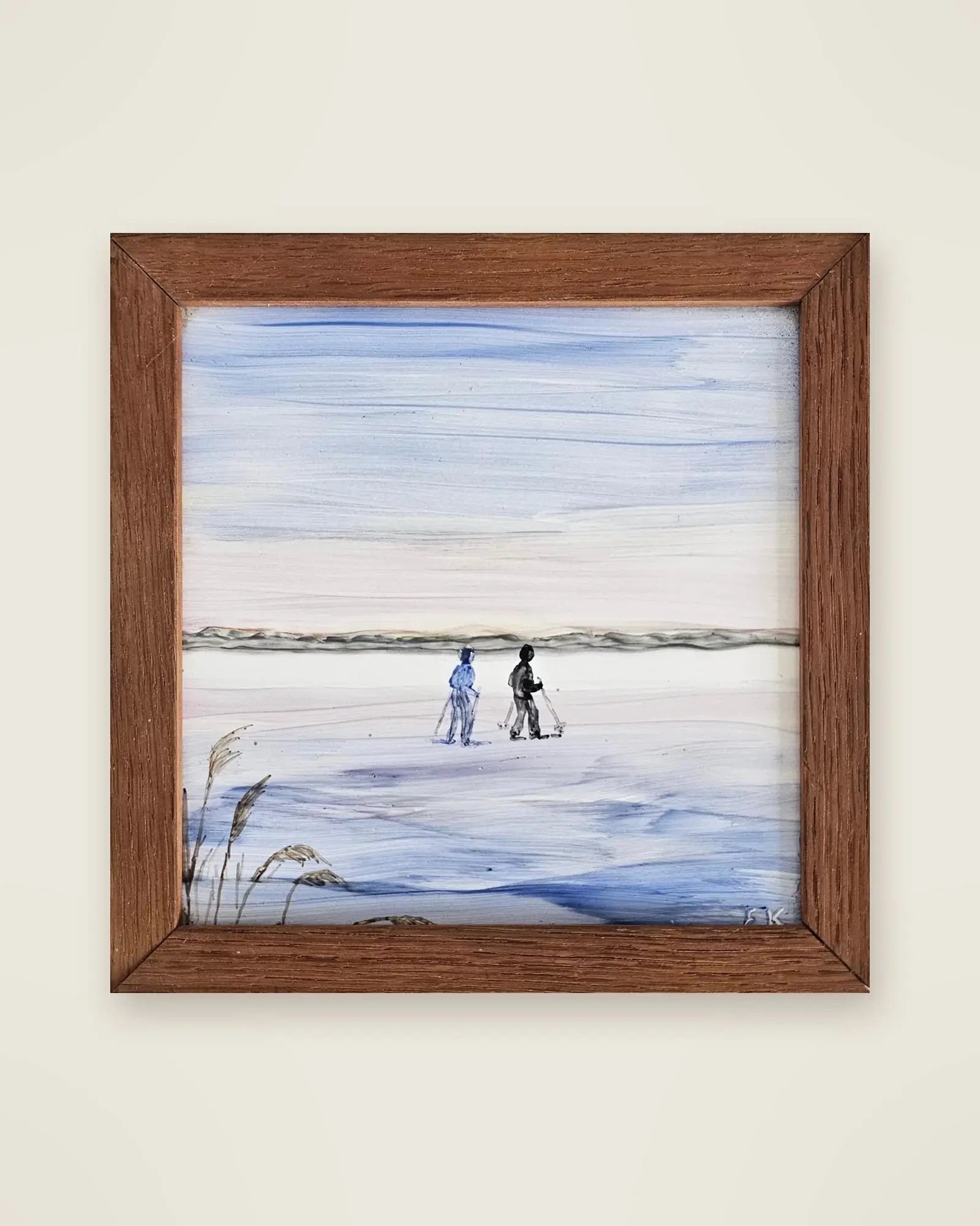 A framed hand-painted ceramic tile by our mum’s aunt: two figures walking across a frozen Finnish lake in winter, signed EK