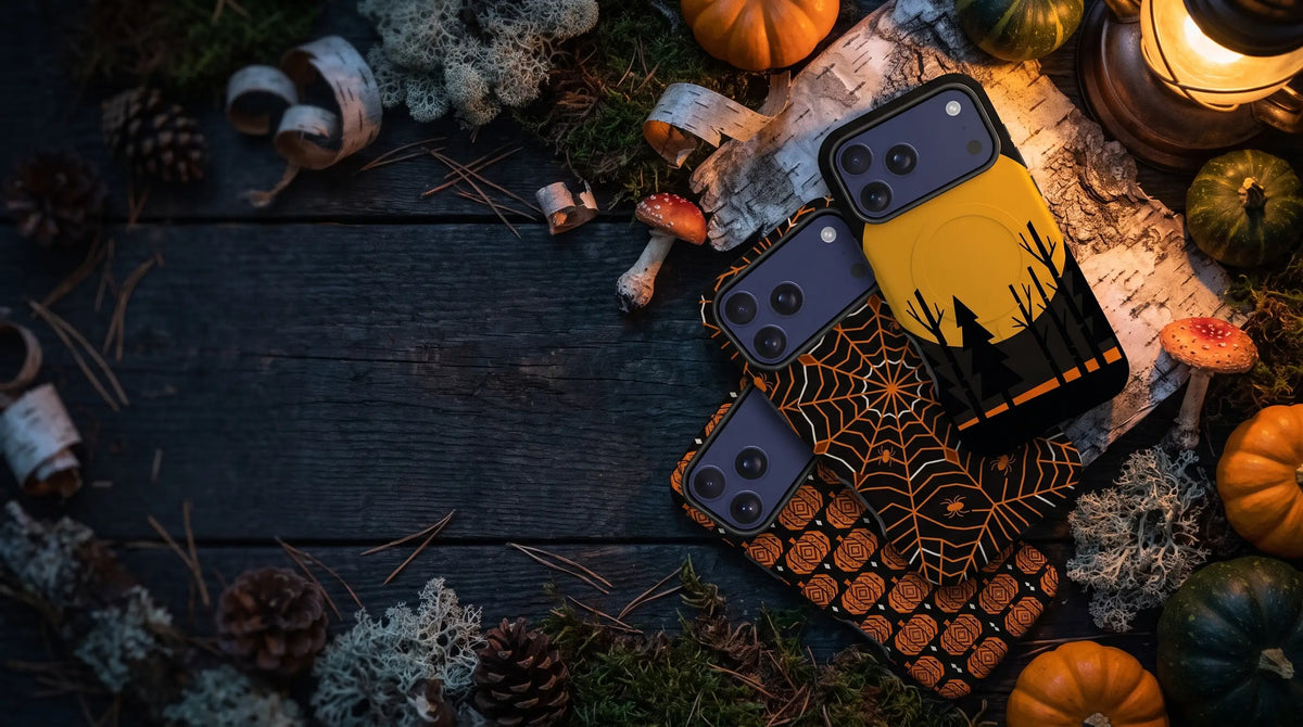 Finnaij Kaamos Dark Season phone cases: Harvest Moon, Spider Runo and Pumpkin Runo on an autumn forest-floor table with pumpkins, birch bark and lantern light